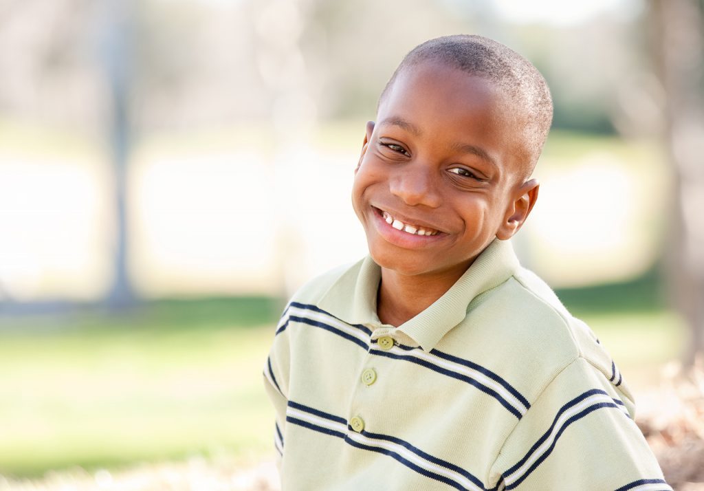 photo of a smiling boy wearing a striped shirt