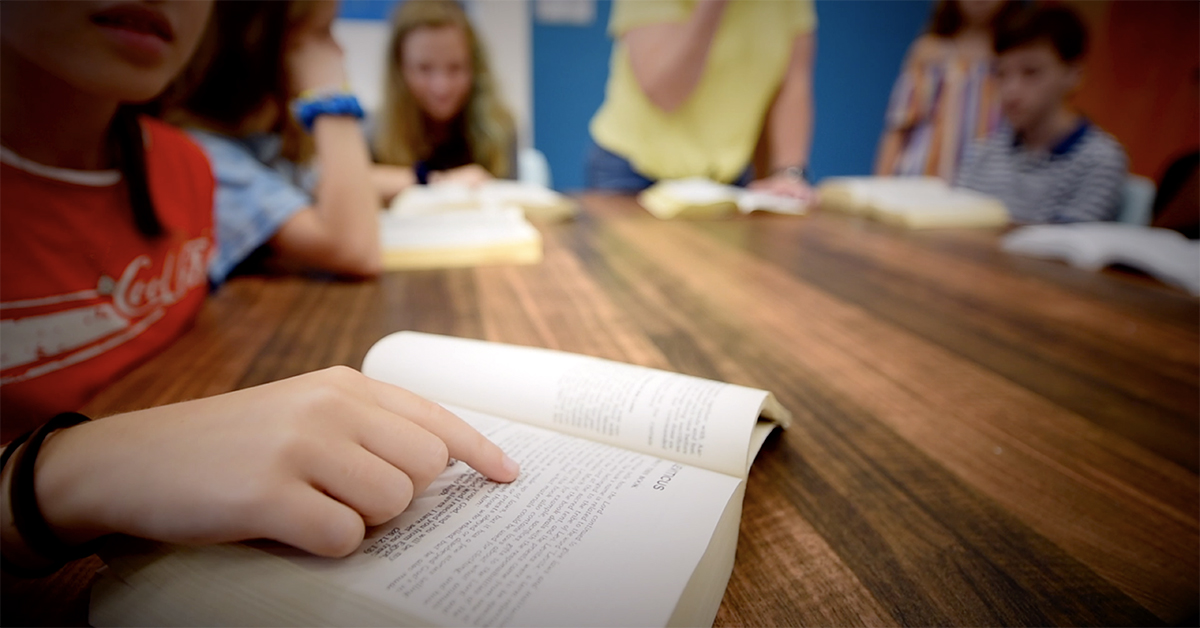 Photo of girl pointing to passage in book