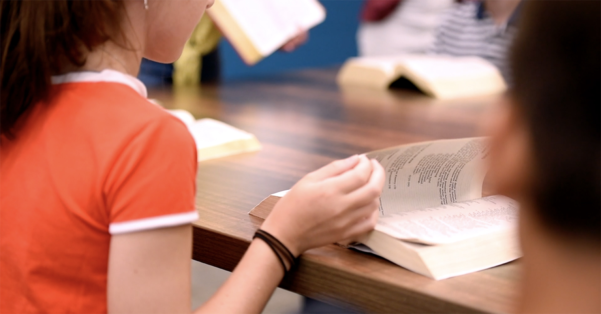 Photo of girl turning the page of a book