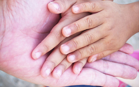 Photo of childrens' hands in an adult's hands