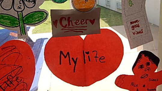 Paper cut-out shapes taped to a window